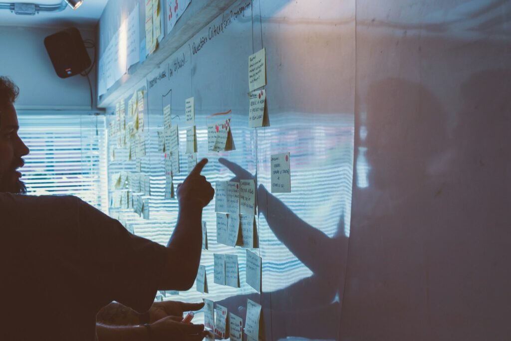 Colleagues mapping out a plan on a wall of notes