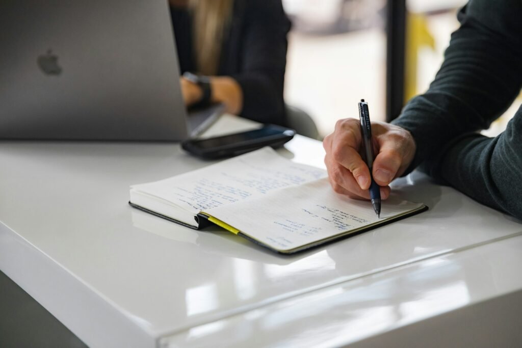 Two people working through notes at a desk